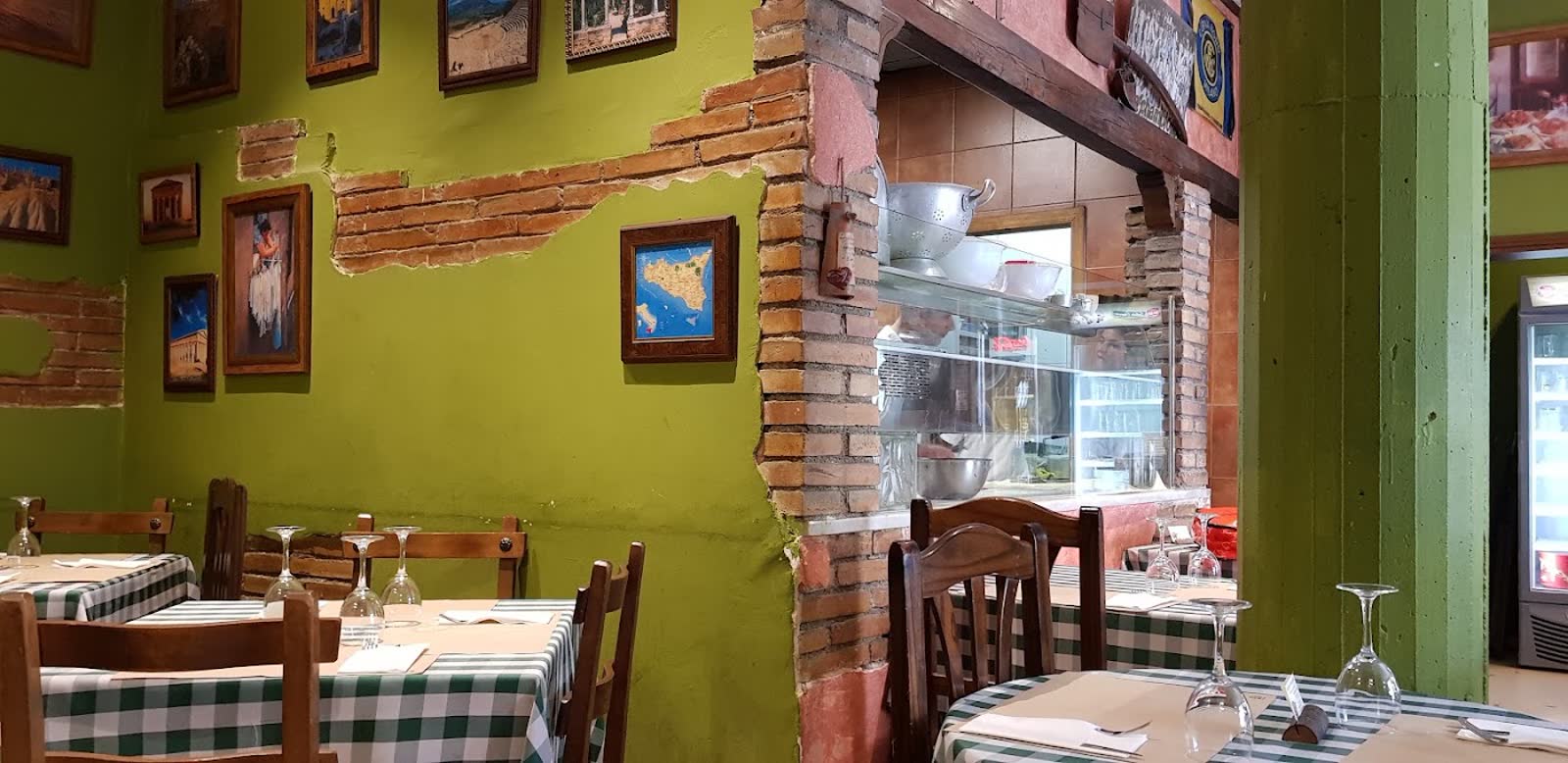 La sala de La Giara en la calle Argensolas, con las paredes verdes, el ladrillo visto y los manteles de cuadros
